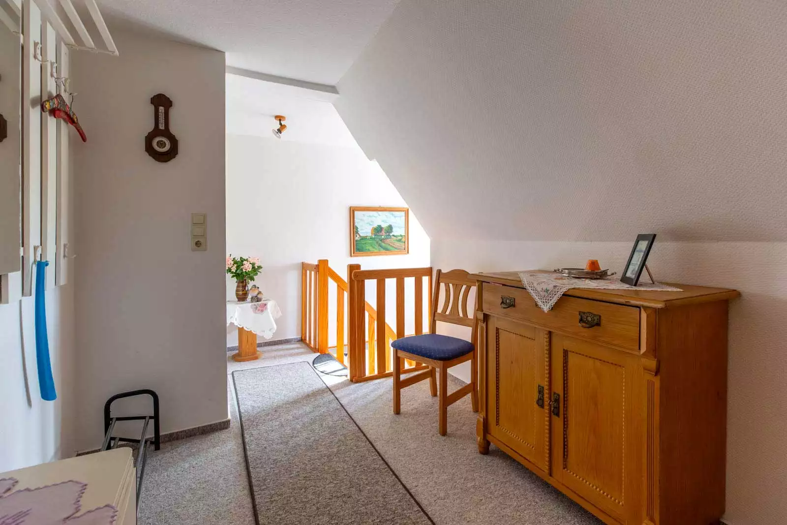 Eingangsbereich mit Garderobe und Blick zur Treppe im Flur der Ferienwohnung Deichgraf