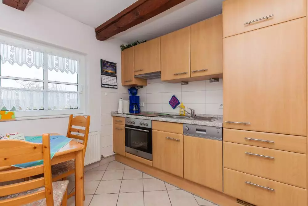 Getrennter Raum mit Einbauküche und Essplatz sowie Blick in den Garten