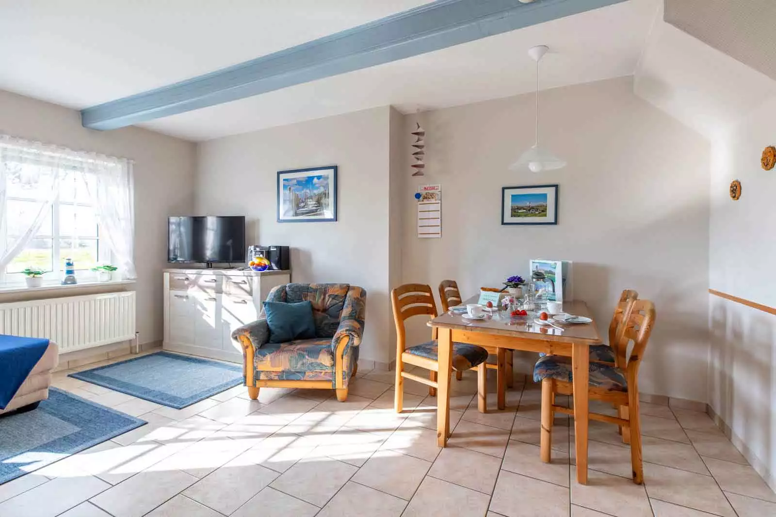 Essbereich mit Fernseher und gedecktem Frühstückstisch in der Ferienwohnung Schimmelreiter