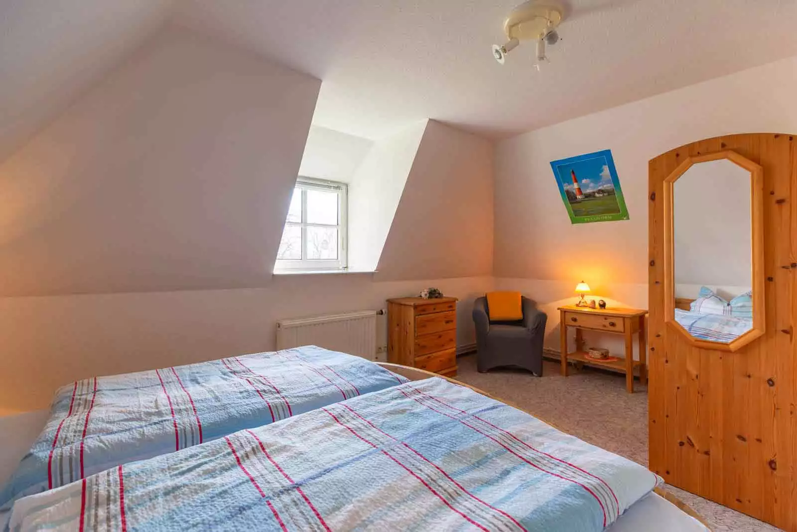 Schlafzimmer mit Doppelbett, Kleiderschrank und Sessel in der Ferienwohnung Schimmelreiter