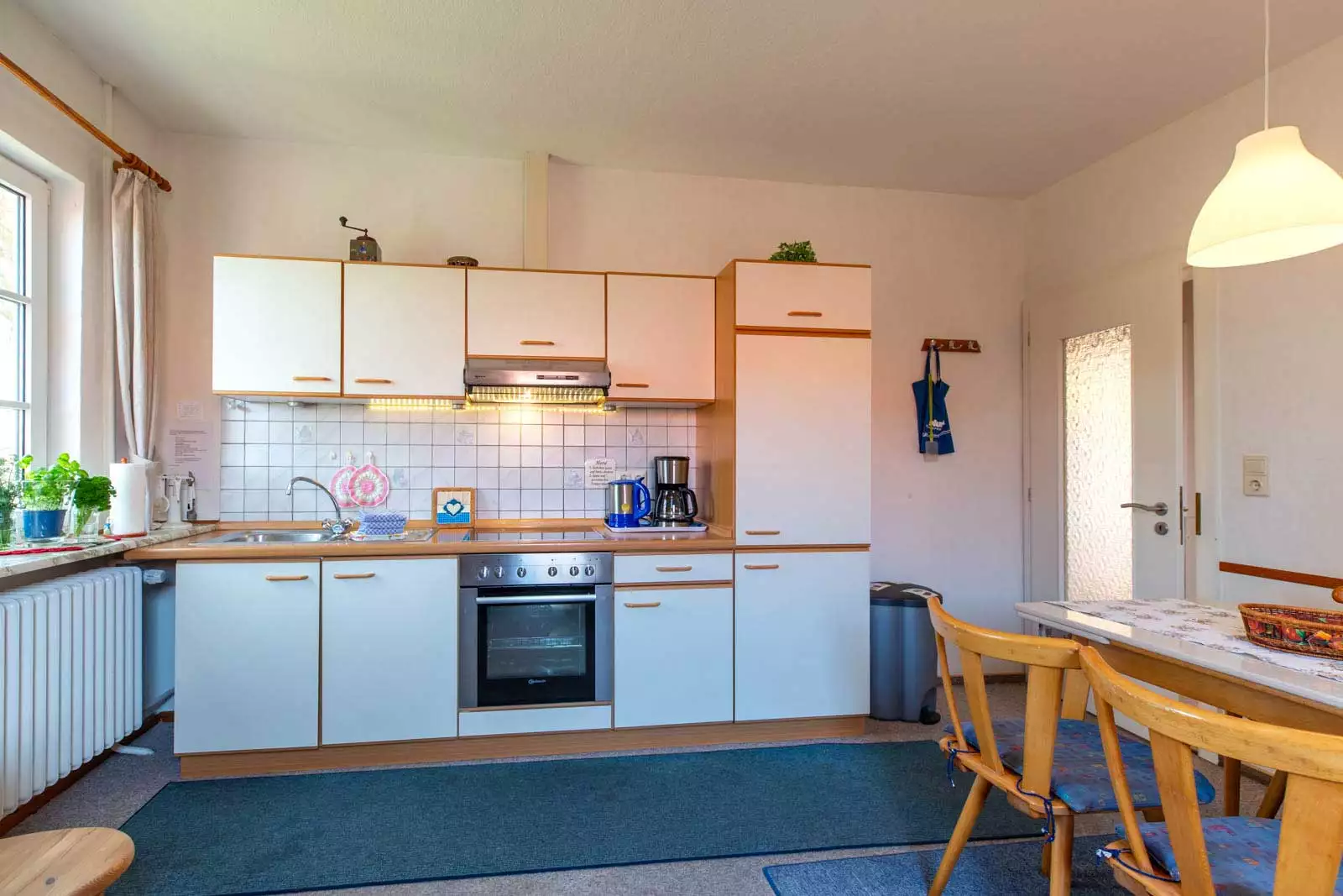 Helle Küche mit Einbauküche und Fenster in der Ferienwohnung Morgensünn