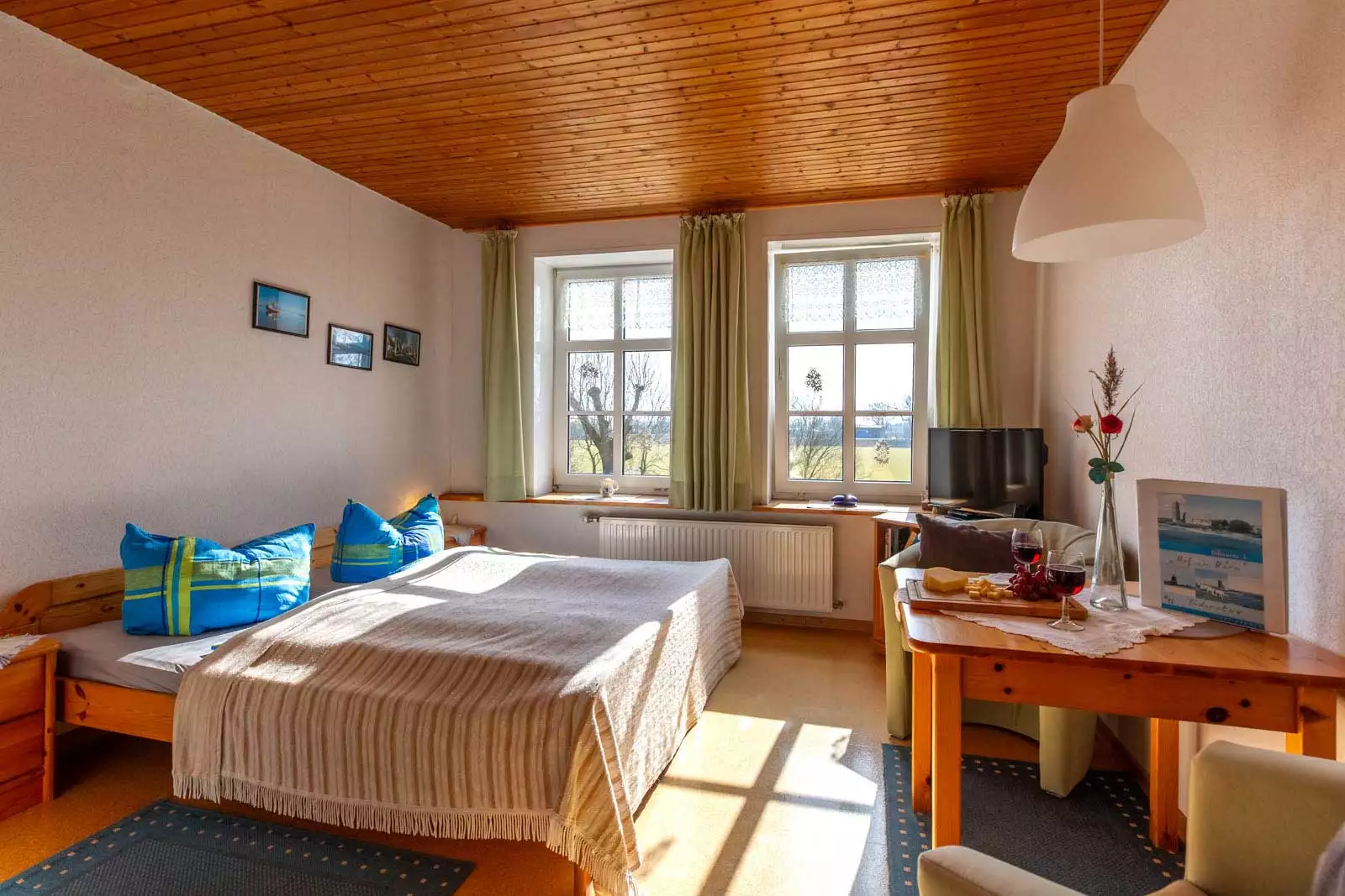 Doppelbett mit Fernseher und gemütlicher Sitzecke im Appartement Süderstuv 