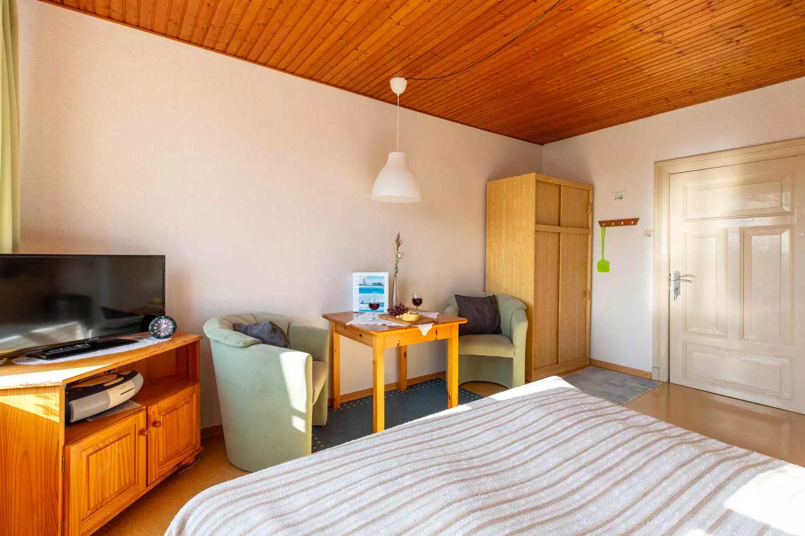 Heller Wohn- und Schlafraum mit Doppelbett und Sitzecke im Appartement Süderstuv