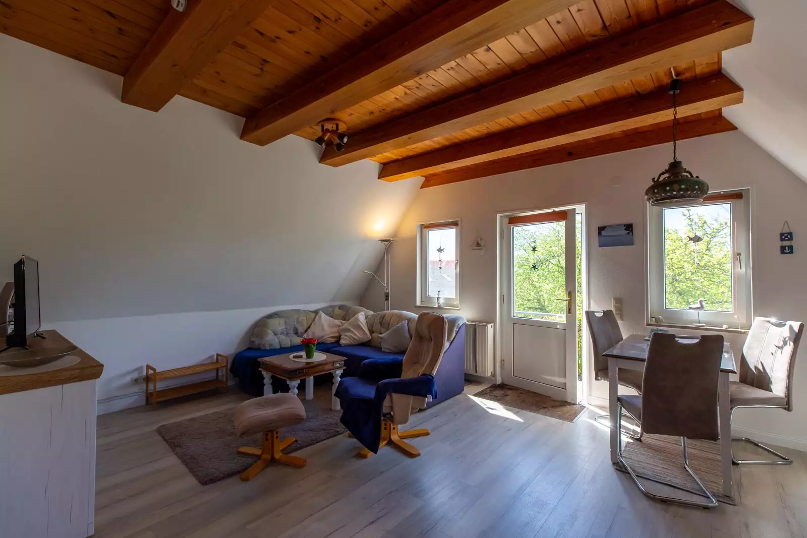 Wohnraum der Ferienwohnung Ankerplatz mit offener Küche und Essplatz am Fenster