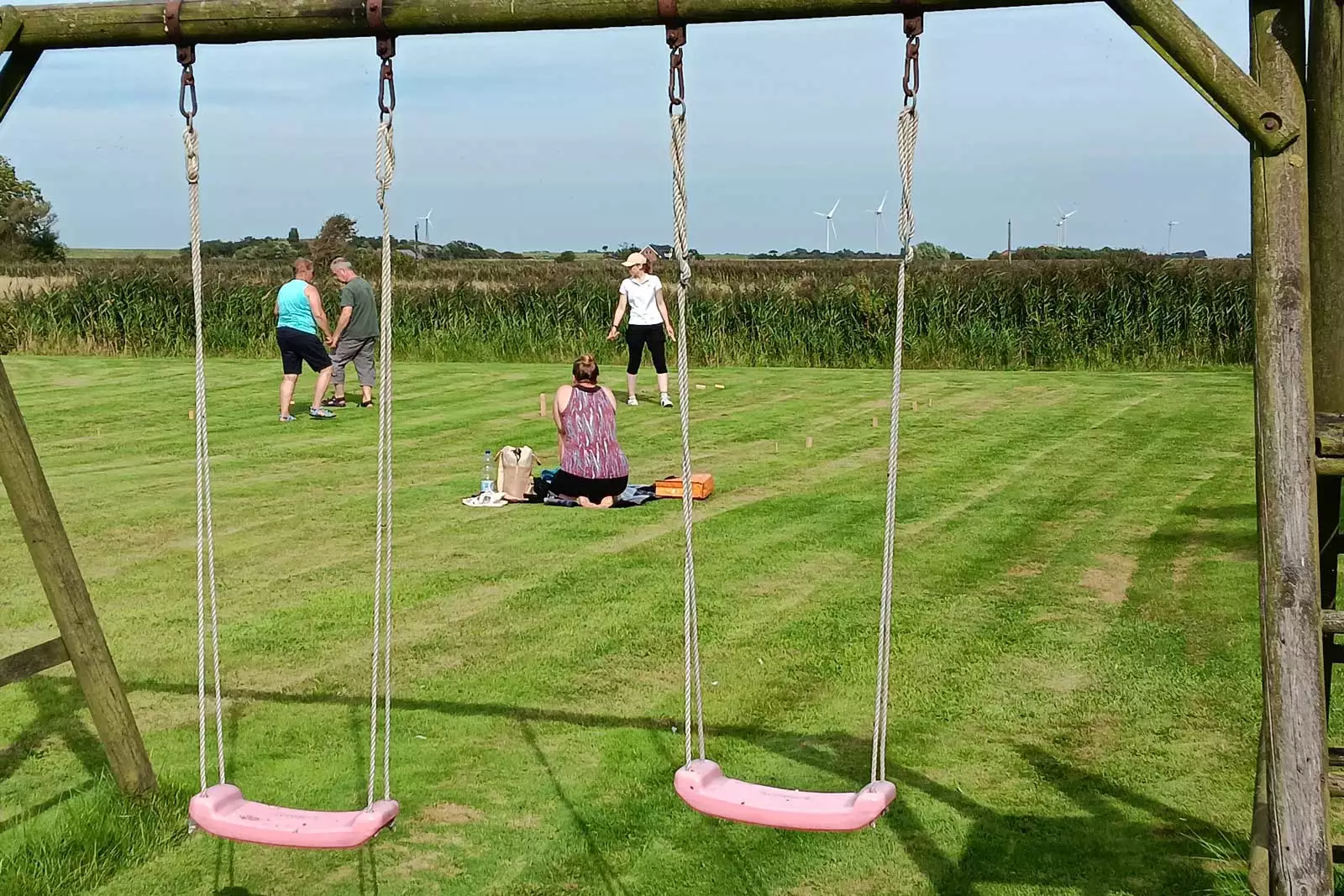 Familie mit Kindern auf einer Wiese mit Schaukel auf Pellworm – Familienurlaub an der Nordsee