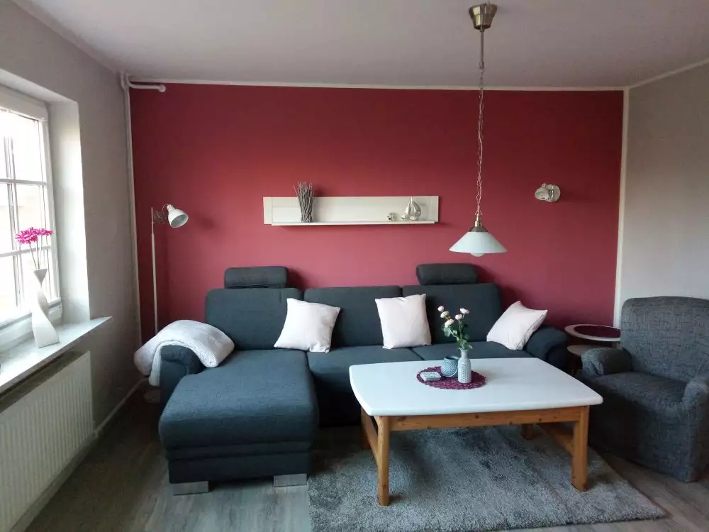 Wohnraum der Ferienwohnung Heimathafen mit Couchecke, Tisch und Sessel