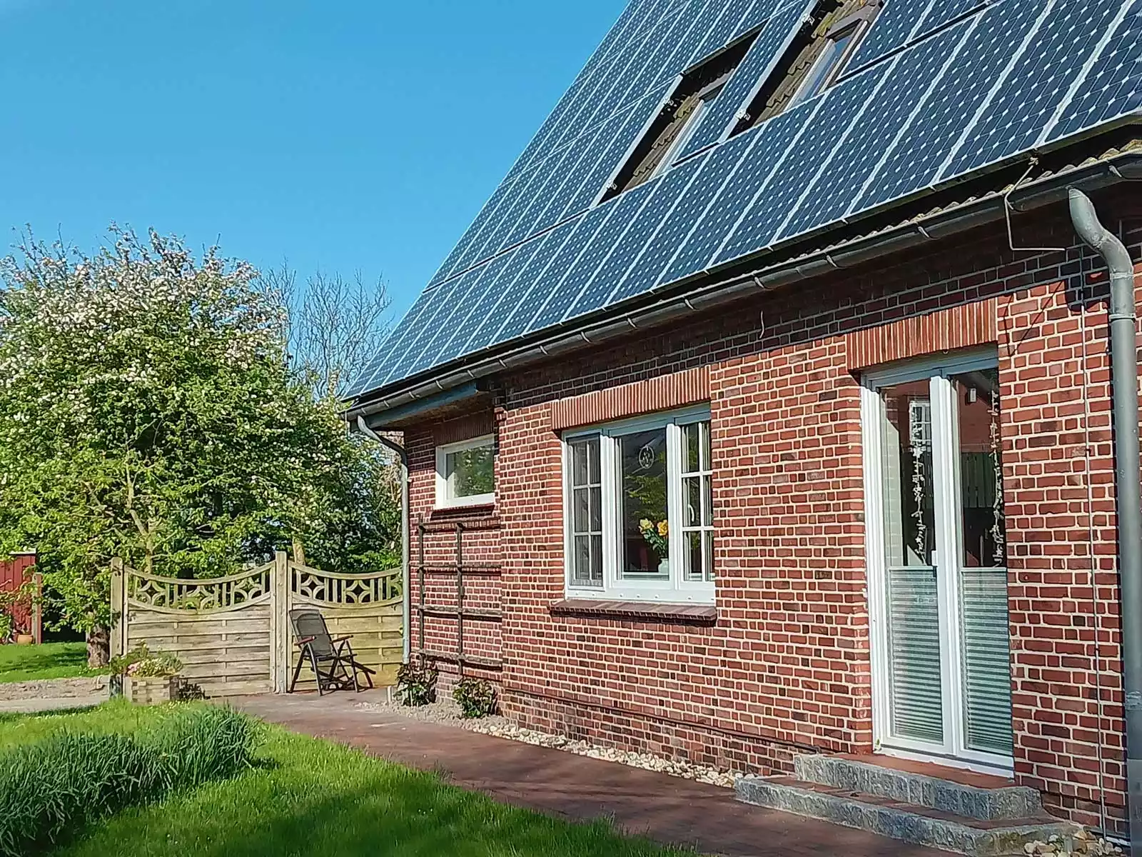 Garten der Ferienwohnung Heimathafen mit Sonnenstuhl und Blick auf das Haus Hafennähe auf Pellworm