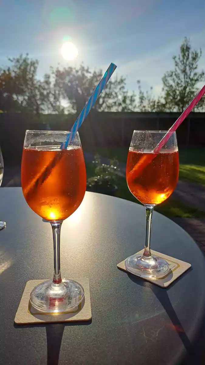 Terrasse der Ferienwohnung Springflot in der Nachmittagssonne mit zwei Gläsern Wein für einen entspannten Tagesausklang