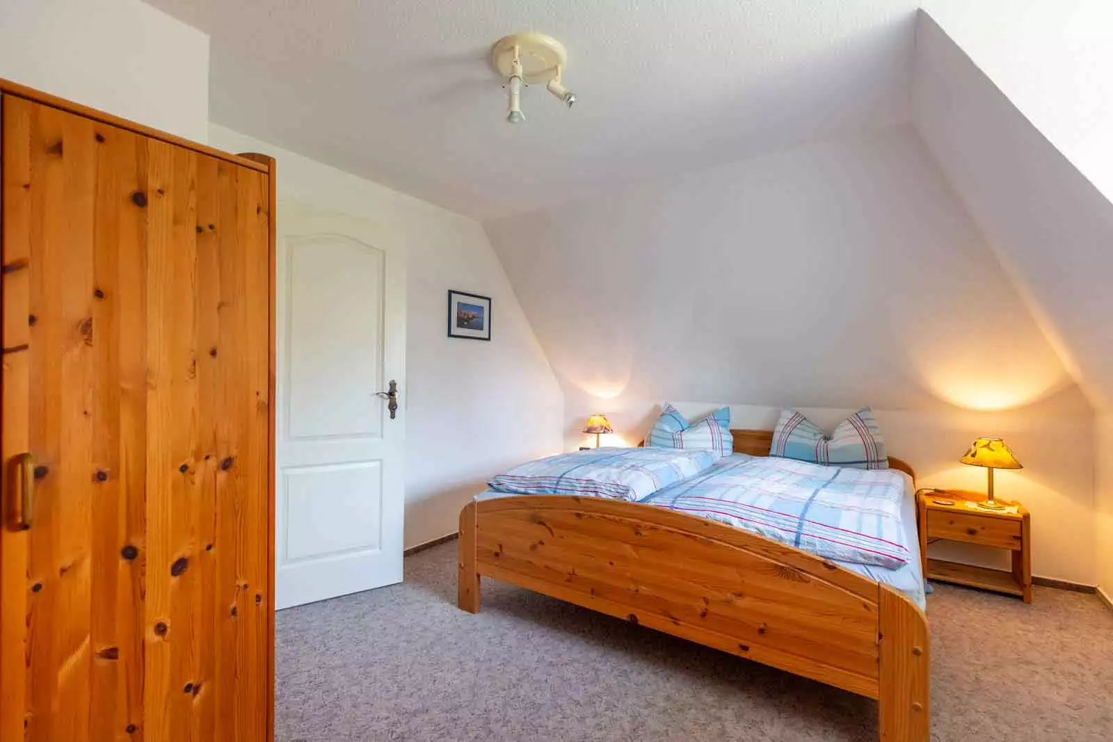 Schlafzimmer mit Doppelbett und Nachttisch in der Ferienwohnung Schimmelreiter